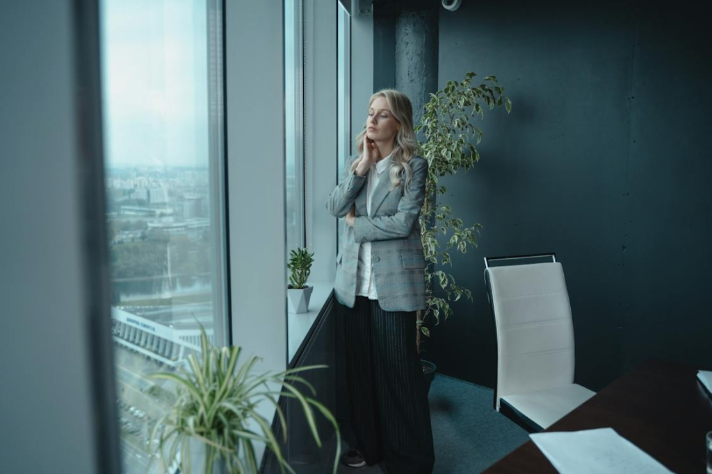 Woman In Gray Coat Standing Near Green Plant
