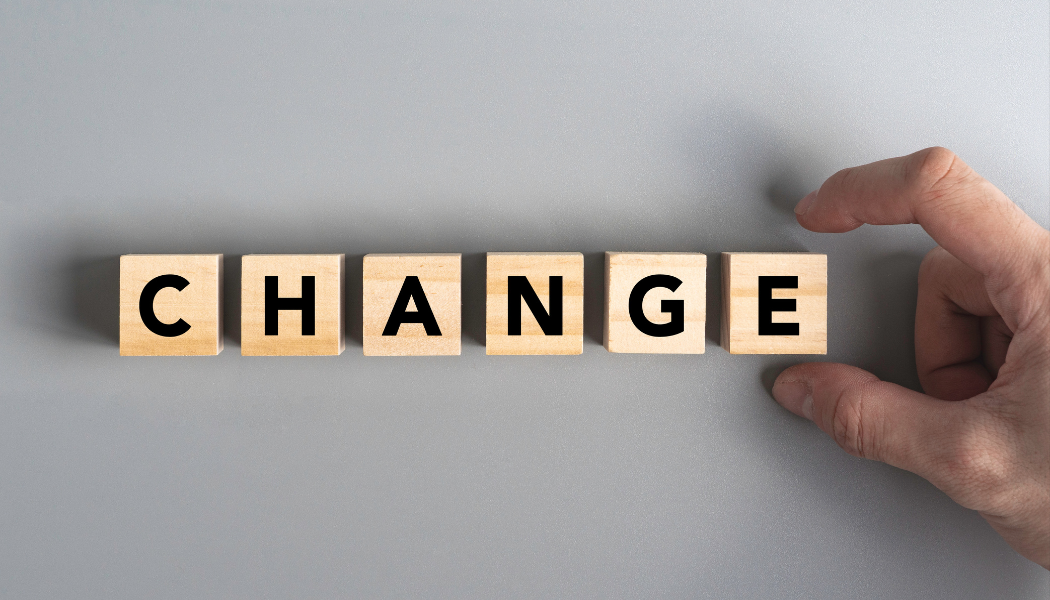 Concept image of change management with hand moving letter blocks